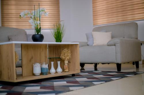 a living room with a couch and a table with vases at Irofo City Apartments in Accra
