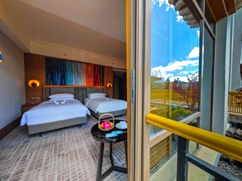 1 dormitorio con 2 camas y balcón en Shangri-La Resort Shangri-La, en Shangri-La