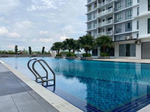 una piscina con una sedia di fronte a un edificio di Paradigm Mall Platino Apartment 2BR 2FREE By Natol a Johor Bahru