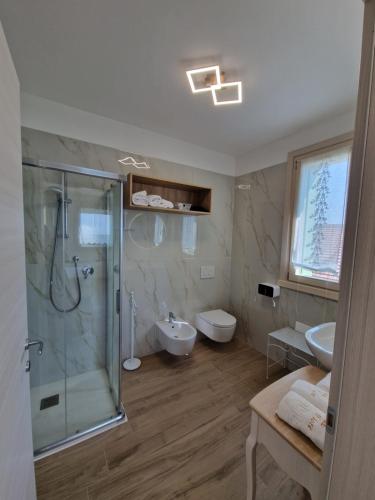 een badkamer met een douche, een toilet en een wastafel bij B&B Fiore in Ganfardine