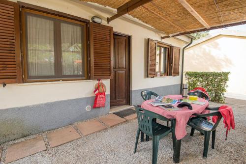 una mesa y sillas frente a una casa en ISA-Appartament standard 4 beds, air conditioning and private outdoor area in Village with 6 swimming-pools en Piombino