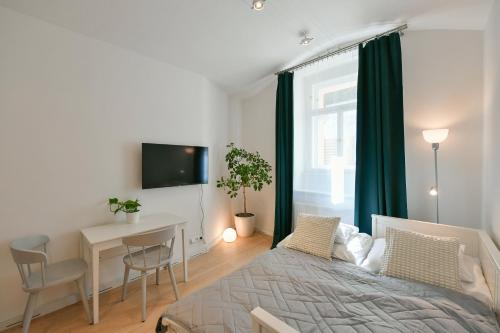 - une chambre avec un lit, une table et une fenêtre dans l'établissement Kubelíkova 32 Residence, à Prague