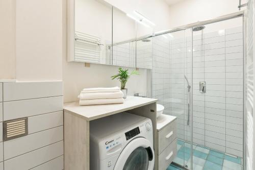 La salle de bains est pourvue d'une douche et d'un lave-linge. dans l'établissement Kubelíkova 32 Residence, à Prague