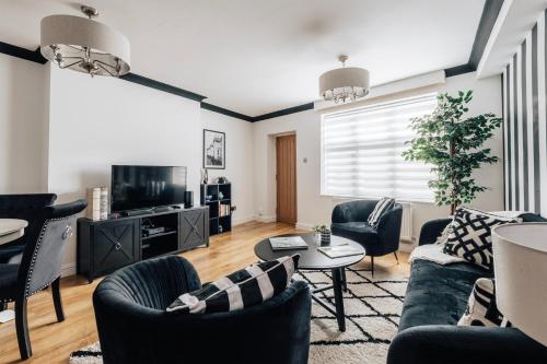 a living room with a couch and chairs and a tv at Stylish 1 Bed Flat Zone 2 Hampstead Swiss Cottage in London