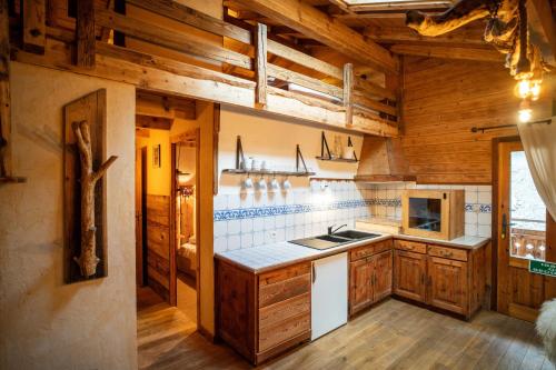 a kitchen with wooden cabinets and a stove top oven at Savoya Lodges in Châtel