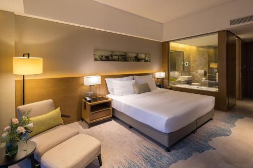 a hotel room with a bed and a bathroom at Wyndham JinJiang Hotel in Jinjiang