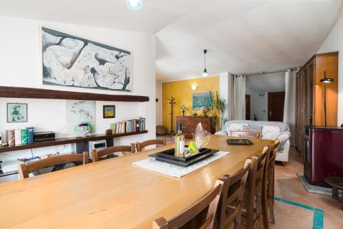 a dining room and living room with a large wooden table at Casa Su Craminu in Dorgali