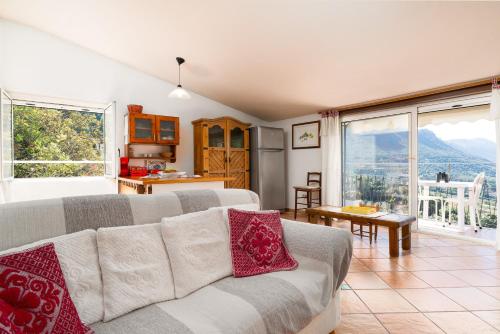 a living room with a couch and a kitchen at Casa Su Craminu in Dorgali