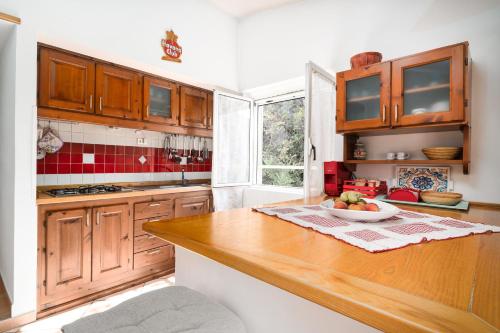 a kitchen with wooden cabinets and a bowl of fruit on a counter at Casa Su Craminu in Dorgali