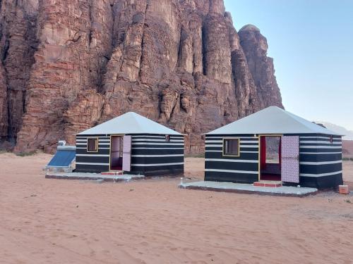 two houses on the beach near a mountain at Wadi Rum fun camp in Wadi Rum