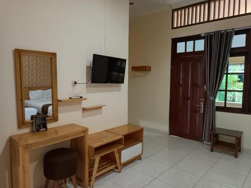 a room with a bed and a desk and a mirror at Shafira Hotel Yogyakarta in Ngabean