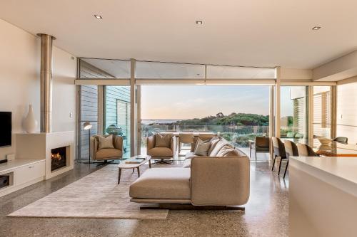 a living room with a couch and chairs and a fireplace at Smiths Beach Resort in Yallingup
