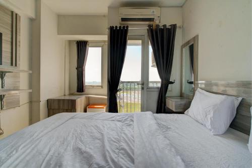 - une chambre avec un grand lit et une fenêtre dans l'établissement OYO Life 92889 Apartement Grand Sentraland Karawang By A.t Room, à Karawang