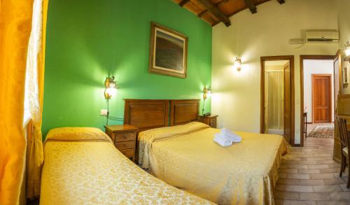 two beds in a room with a green wall at Country House Il Cascinale in Colonnella