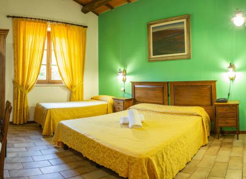 a bedroom with two beds and a green wall at Country House Il Cascinale in Colonnella