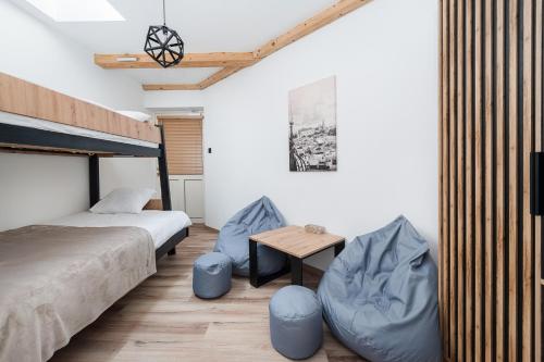 a bedroom with a bed and two blue chairs at WAWELOFT APARTMENT in Kraków