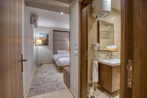 een kleine badkamer met een wastafel en een bed bij NOZOL PYRAMIDS HOTEL in Caïro