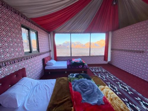 a bedroom with a bed in a pink room with windows at Wadi Rum fun camp in Wadi Rum