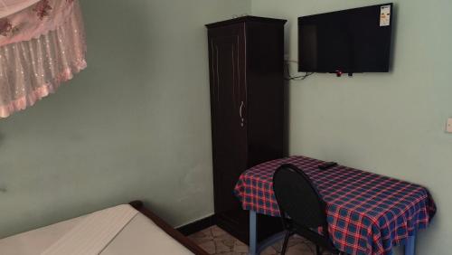 a room with a table and a cabinet and a television at Dodoma Siesta Inn in Dodoma