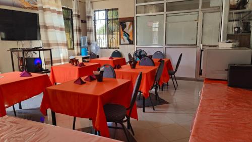 una clase con mesas rojas y sillas en una habitación en Dodoma Siesta Inn, en Dodoma