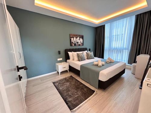 a bedroom with a bed and a large window at HADRİANS TOWER in Antalya