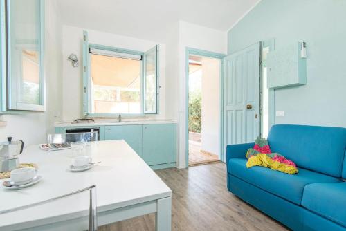 sala de estar con sofá azul y mesa en ISA-Appartament Charme, 4 beds, air conditioning and private outdoor area in Village with 6 swimming-pools, only 1 km from the beach en Piombino