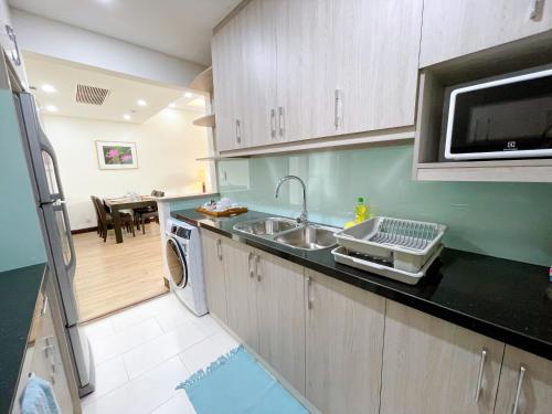 a kitchen with a sink and a microwave at Diamond Westlake Suites in Hanoi
