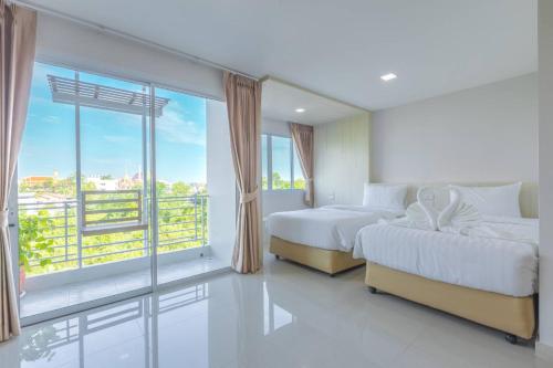 a bedroom with two beds and a large window at Sananwan Hometel in Ban Bang Phli Yai