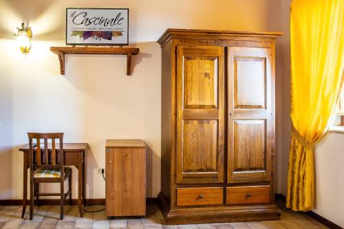a wooden cabinet next to a table and a chair at Country House Il Cascinale in Colonnella