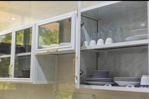 a kitchen cabinet with plates and dishes in it at JOY B Apartment 2 in Kiembi Samaki