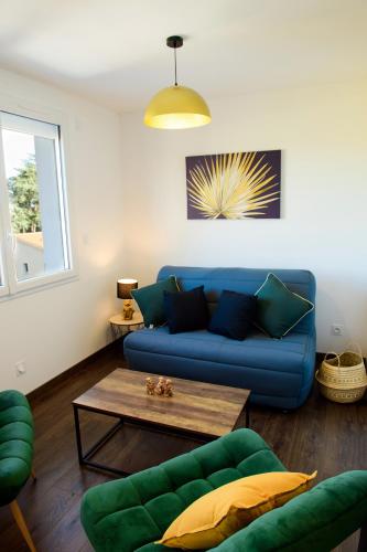 a living room with a blue couch and a table at Le Forez Appartement 4 pers ou Studio 2 pers in Cuzieu