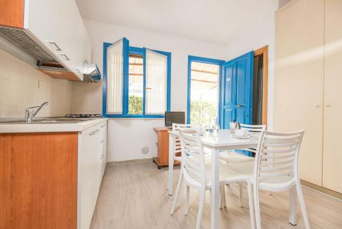 uma cozinha com uma mesa e cadeiras numa cozinha em ISA-Appartament plus 4 beds, air conditioning and private outdoor area in Village with 6 swimming-pools em Piombino