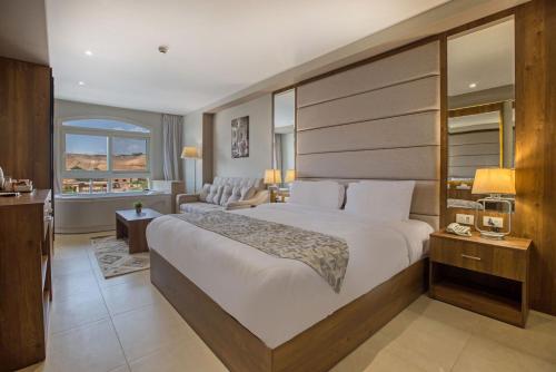 een slaapkamer met een groot bed en een woonkamer bij NOZOL PYRAMIDS HOTEL in Caïro