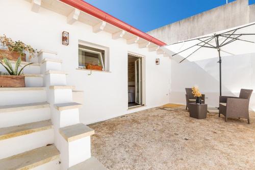 a white house with a patio and stairs at Dimora Ferente in Salve