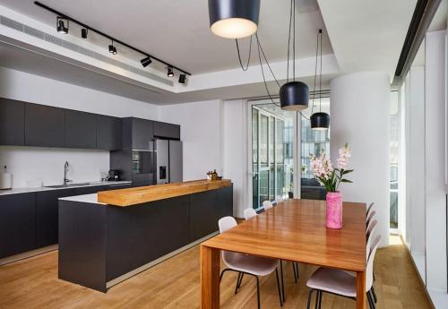 uma cozinha e sala de jantar com uma mesa de madeira em Meier on Rothschild 36 em Tel Aviv
