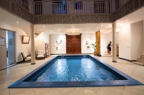 ein großer Pool in einem Zimmer mit einer Person im Hintergrund in der Unterkunft Riad Bibazia in Marrakesch