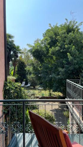 a chair on a balcony with a view of a park at Ai Giardini di San Vitale in Ravenna