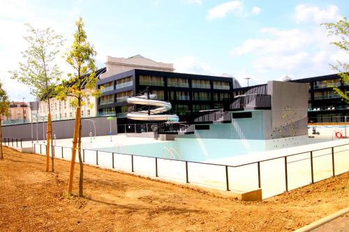 un immeuble avec une piscine devant un immeuble dans l'établissement LE CHALET DES THERMES, à Nancy