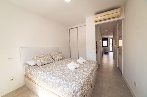 a white bedroom with a large bed with two pillows at VISTALEGRE Apartments in Madrid