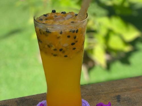 a glass of orange juice with black raisins on a table at Bloom Garden Bed & Breakfast in Siem Reap