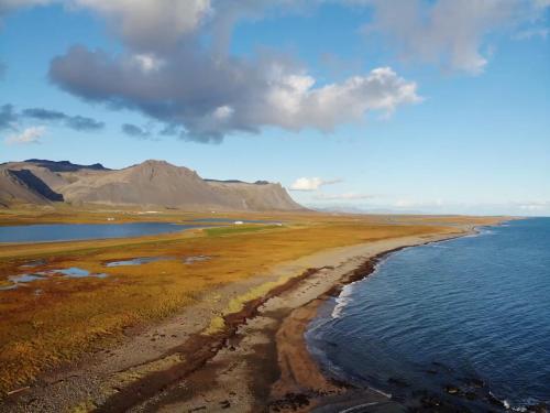 an aerial view of a beach with a mountain in the background at Vatnsholt in Snæfellsnes - Birta Rentals in Snæfellsbær