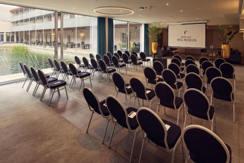 a conference room with chairs and a screen in a building at Van der Valk Hotel Mechelen in Mechelen