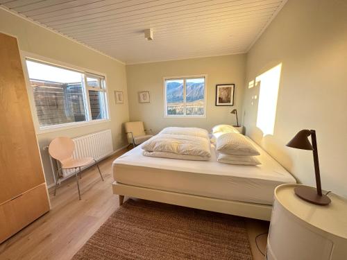 a bedroom with a bed and two windows at Modern and spacious Holiday Home with Hot Tub in Snæfellsbær