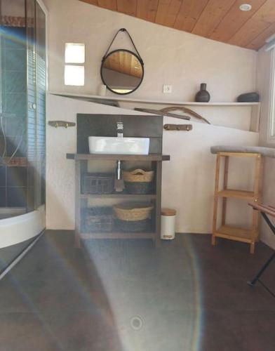 une salle de bain avec un lavabo et un miroir dans l'établissement Maison 3 chambres vue Mer, à Grosseto-Prugna