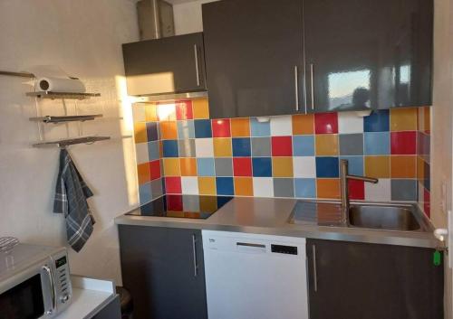 - une cuisine avec du carrelage coloré sur le mur dans l'établissement Maison 3 chambres vue Mer, à Grosseto-Prugna