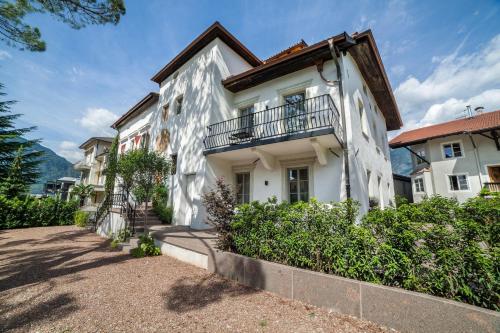 a white building with a balcony on it at Ansitz Layshof Apartment Turm in Merano