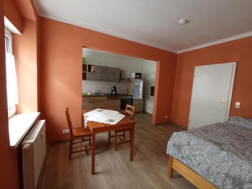um quarto com uma mesa, uma cama e uma cozinha em kleine 1-Raum-Ferienwohnung mit hohem Komfort em Teuchern