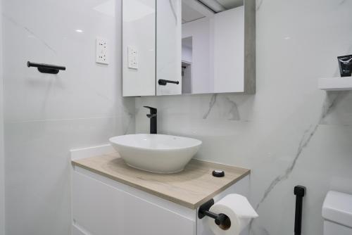 een badkamer met een witte wastafel en een spiegel bij Luxurious Apt with Balcony The greens Dubai in Dubai