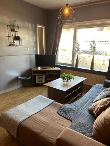 1 dormitorio con cama, mesa y TV en Hotel Velsen, en IJmuiden