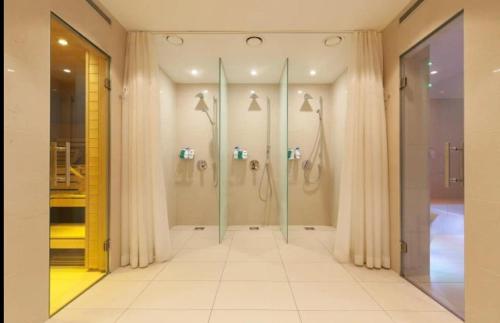 a bathroom with four shower stalls in a room at Luxorius living in the heart of St. Moritz Dorf in Celerina